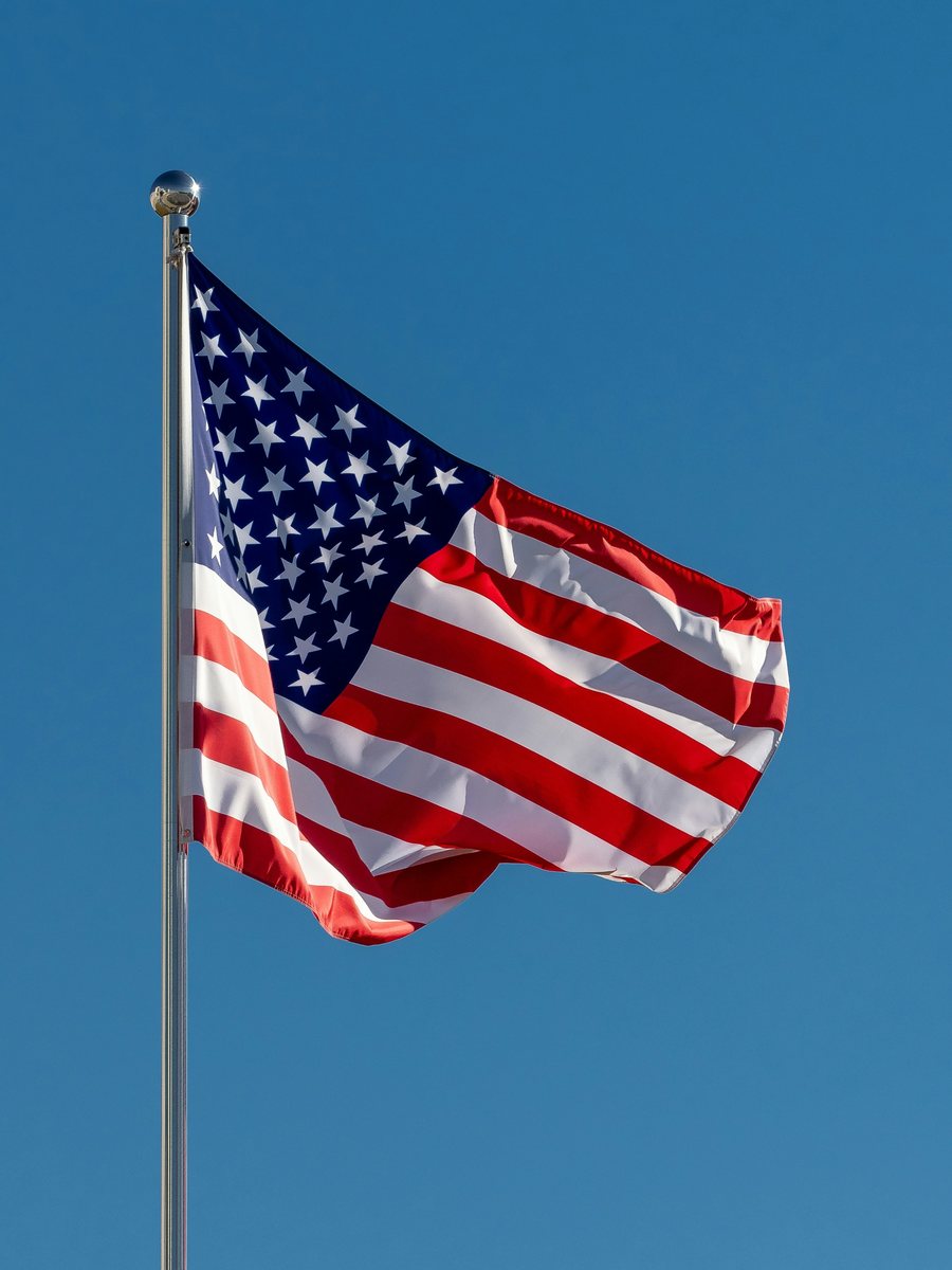 US-Flagge an einem Fahnenmast vor blauem Himmel