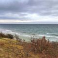 Steilküste und schmaler Strand auf Bornholm an der Ostsee unter bewölktem Himmel