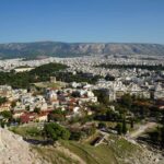 Panorama von Athen vom Areal der Akropolis mit antiken Säulen im Vordergrund und dem Hymettos-Gebirge