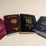 Vier Reisepässe (Spanien, Frankreich, Israel und USA) fächerförmig auf einer hellen Fläche