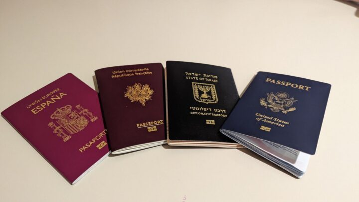 Vier Reisepässe (Spanien, Frankreich, Israel und USA) fächerförmig auf einer hellen Fläche