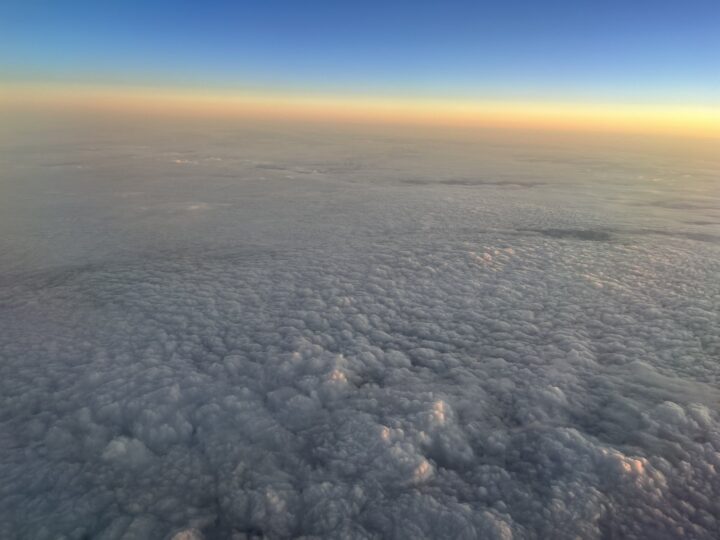 Geschlossene Wolkendecke aus der Vogelperspektive mit goldenem Horizontstreifen